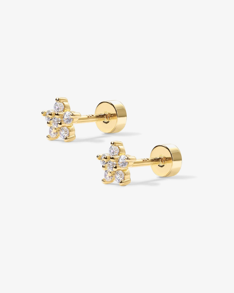 Pair of gold stud earrings with clear gemstones on a white background