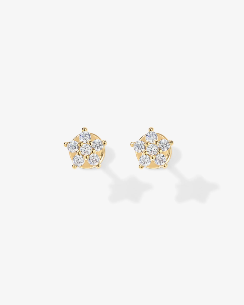 Gold earrings with diamond-like stones on a white background