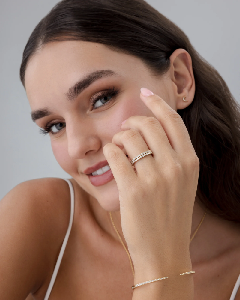 Model wearing ultra-thin gold stackable ring on ring finger