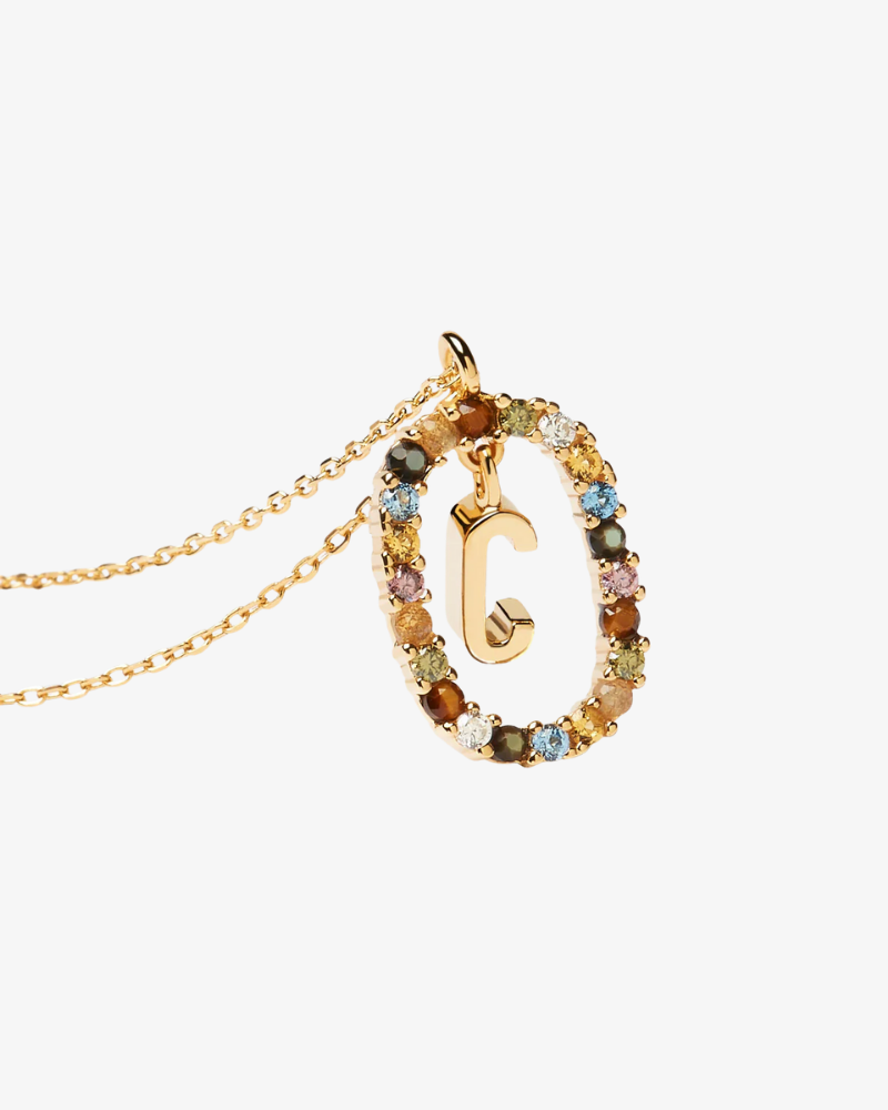 Necklace with a gold 'C' pendant featuring multicolored stones on a white background