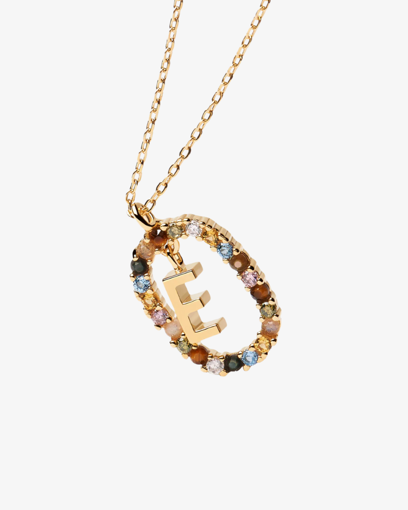 Gold necklace with a circular pendant featuring the letter 'E' and multicolored stones on a white background.