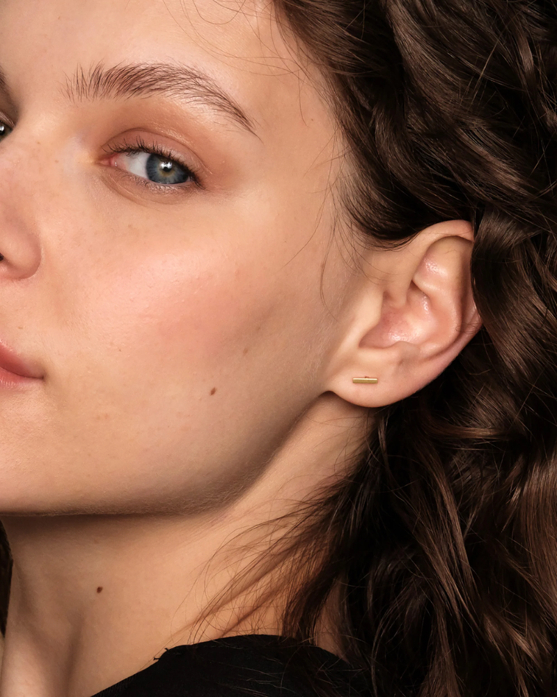 Close-up of a person's ear with a delicate earring