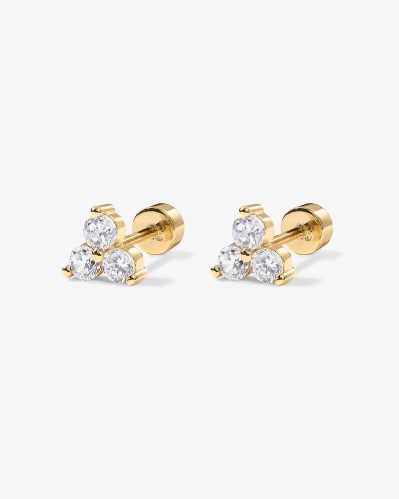 Pair of gold stud earrings with clear gemstones on a white background
