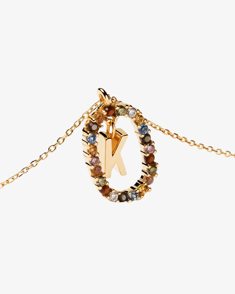Gold necklace with a multicolored 'K' pendant on a white background
