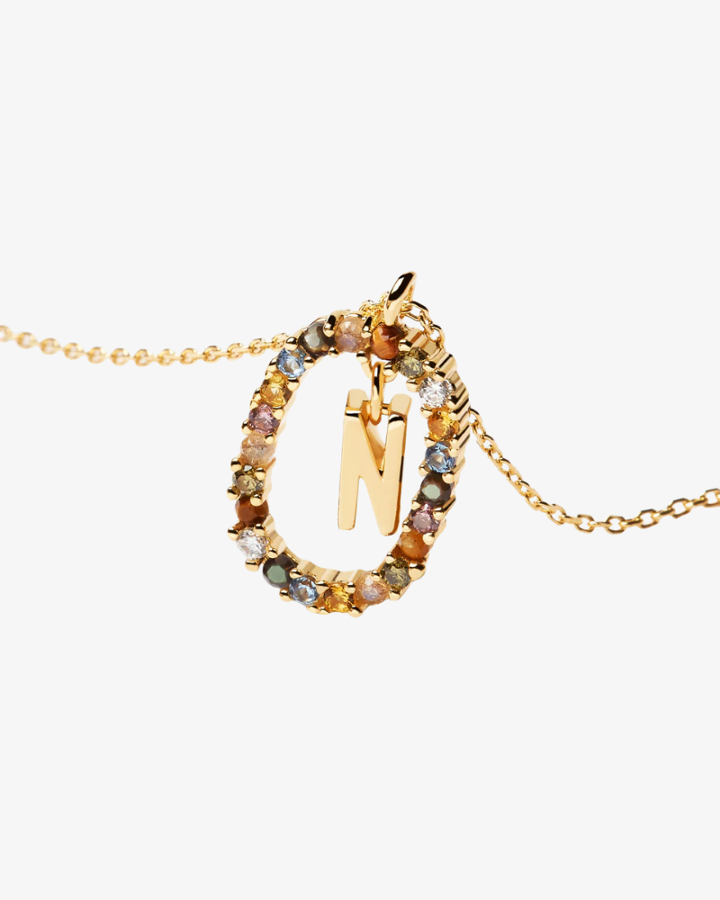 Gold necklace with a circular pendant featuring the letter 'N'