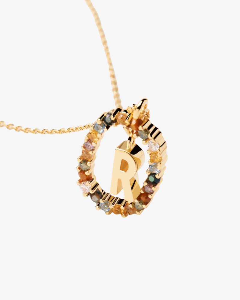 Gold necklace with a circular pendant featuring the letter 'R'.