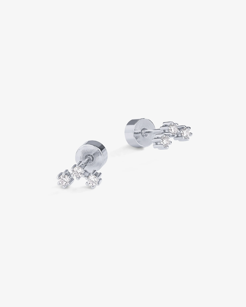 Pair of silver earrings with clear gemstones on a white background